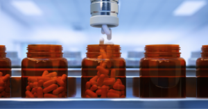 Automated pharmaceutical production line filling capsule bottles in a modern manufacturing facility, illustrating oral solid dosage form manufacturing and excipient demand in Canada.