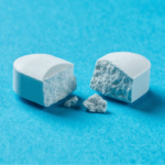 Cross-section of a coated pharmaceutical tablet showing formulation layers, illustrating oral delivery of biologics
