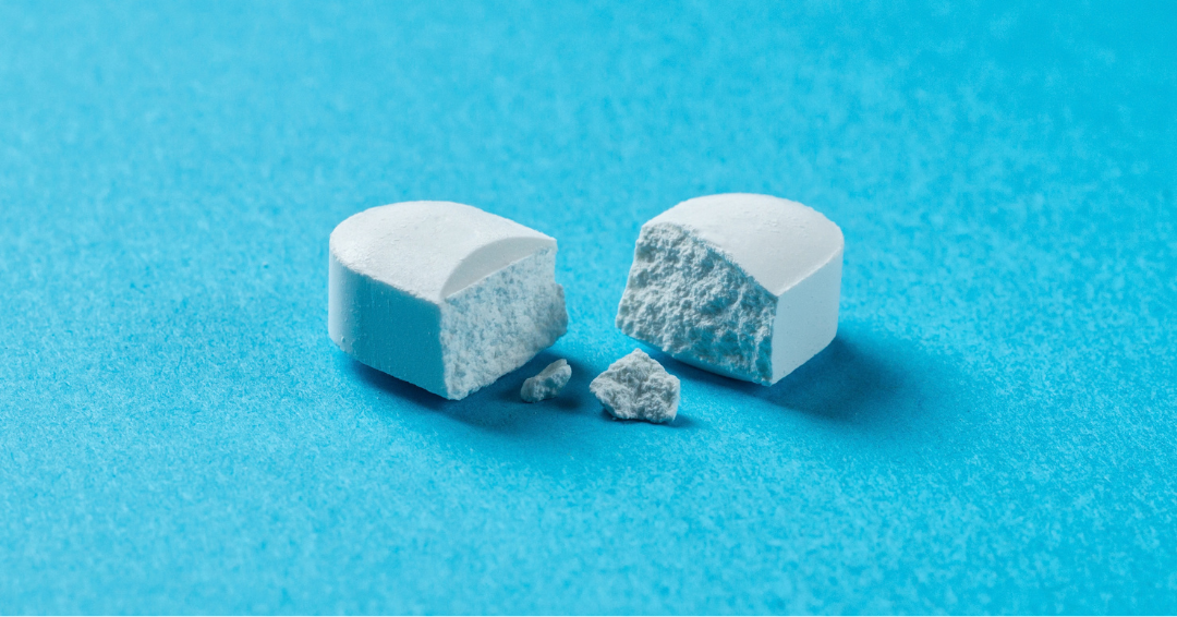 Cross-section of a coated pharmaceutical tablet showing formulation layers, illustrating oral delivery of biologics