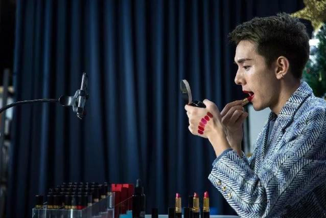Austin tries on lipsticks while live broadcasting on social media.