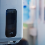 Wall-mounted touch-free hand sanitiser dispenser in a commercial public entrance