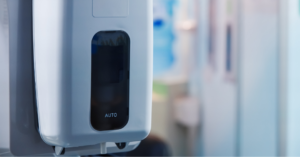 Wall-mounted touch-free hand sanitiser dispenser in a commercial public entrance